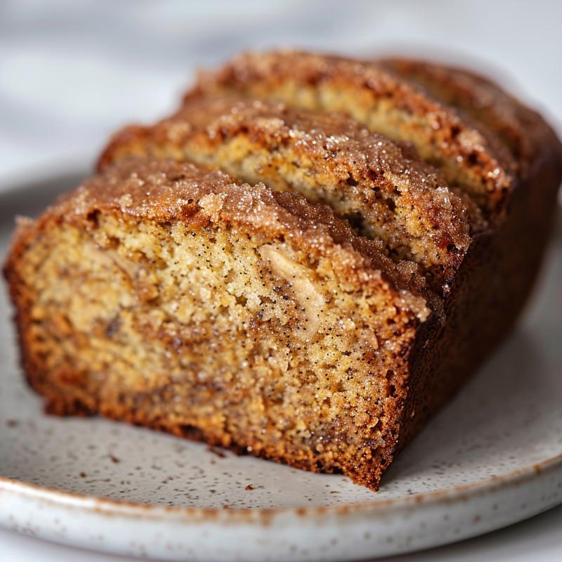 Close-up of a slice of brown sugar banana bread on a grey ceramic plate.